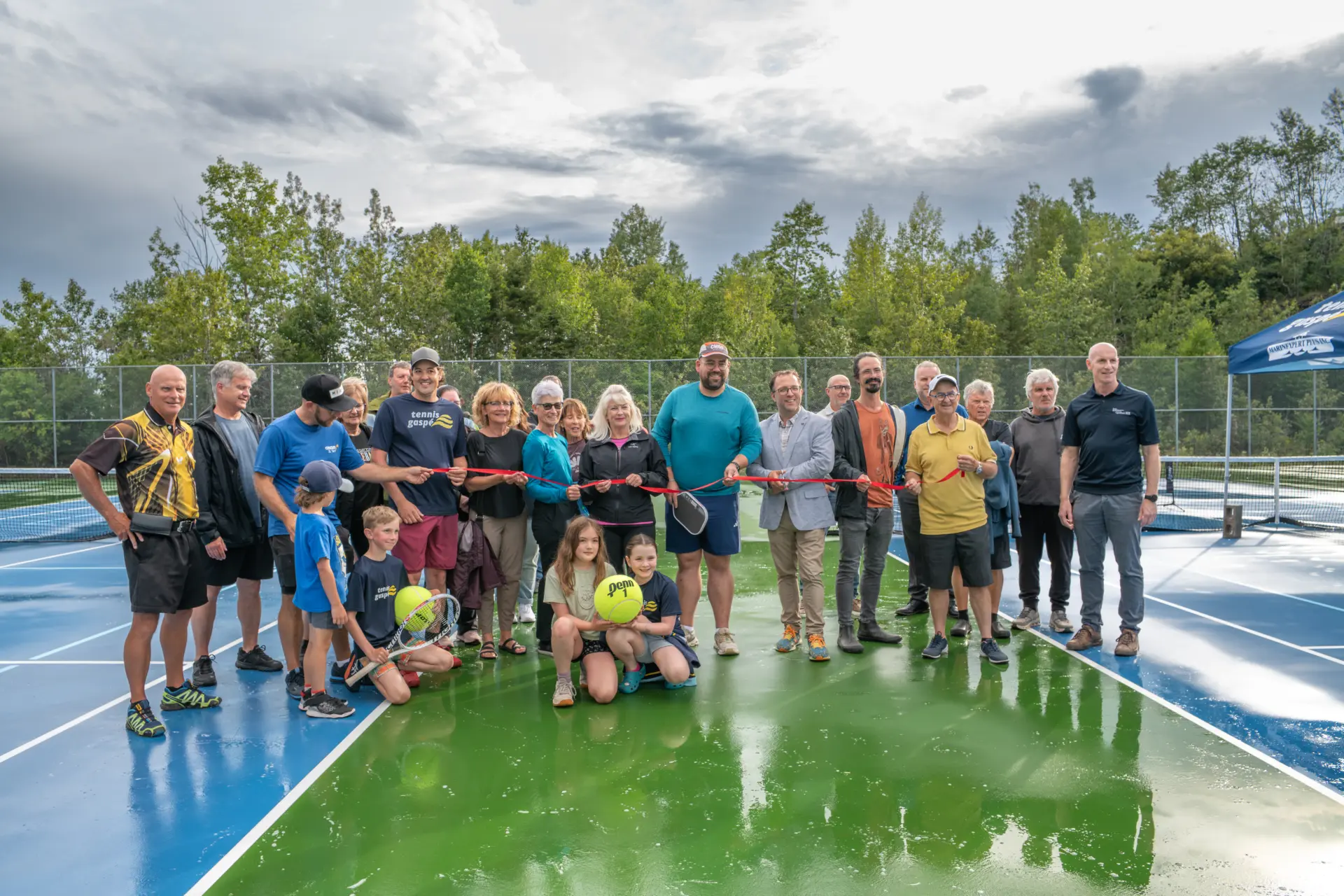 Group celebrating new tennis court opening